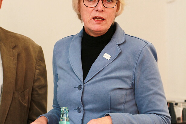 Man sieht eine Frau die zur Kamera schaut und redet