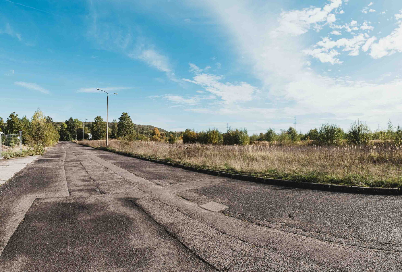 Eine alte geteerte Straße, die schon oft geflickt wurde.