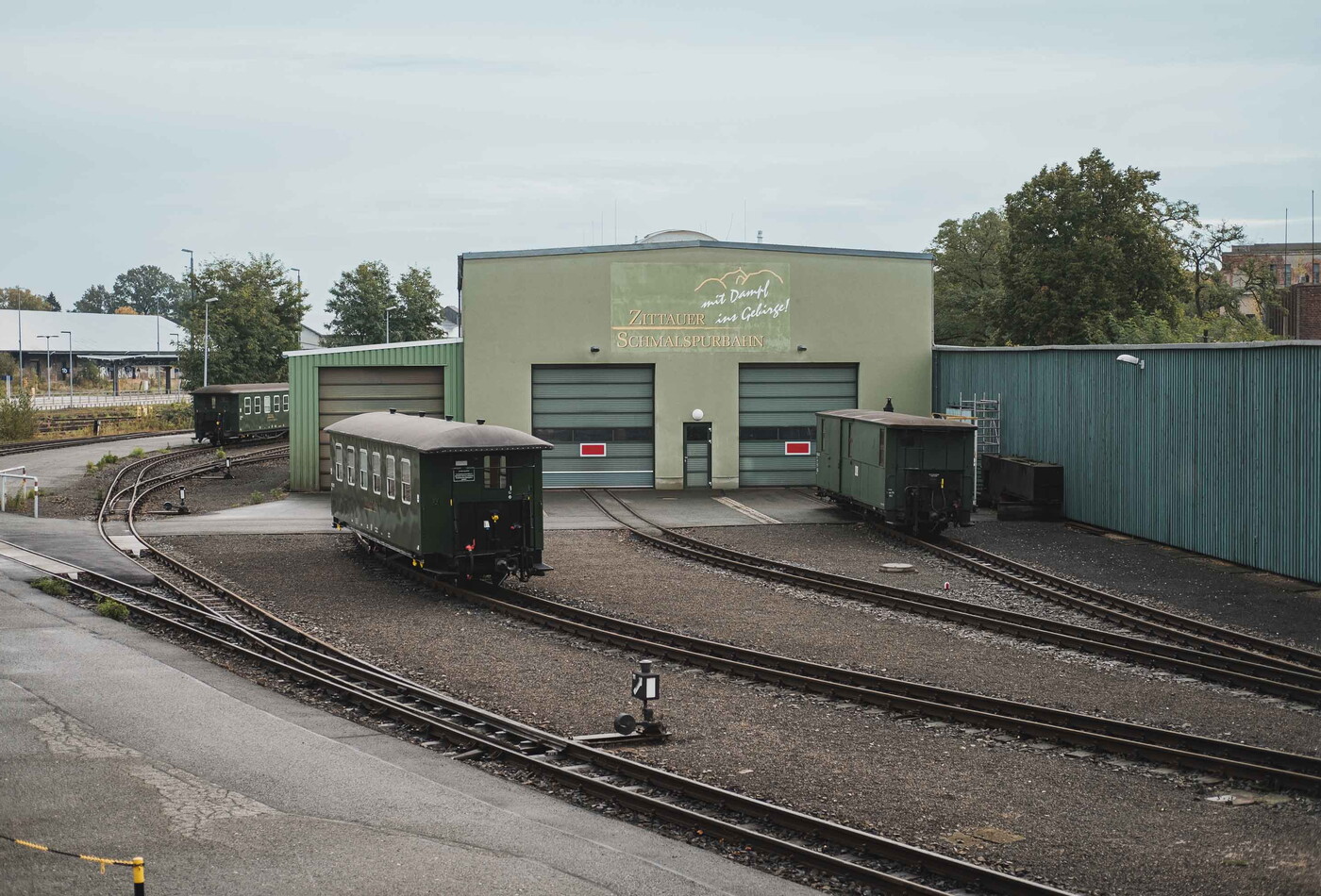 Schienen auf denen Wagons stehen die in ein Gebäude führen.