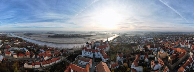 Eine Luftaufnahme der Stadt Torgau. Zu sehen sind das Schloss Hartenfels und die Elbe.