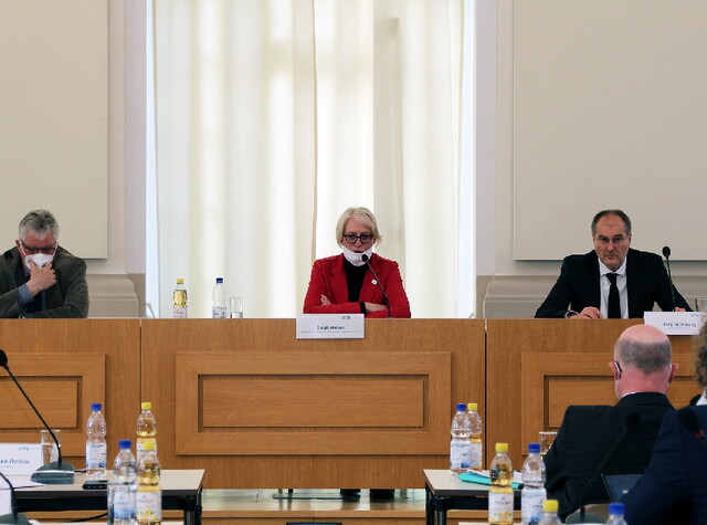 zusehen sind die drei Personen die an ihrem Pult sitzen