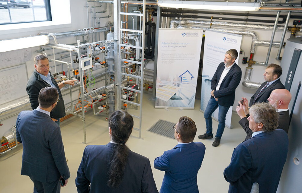 Männern in Anzügen wird in einer Hochschule etwas über Elektrizität erklärt.