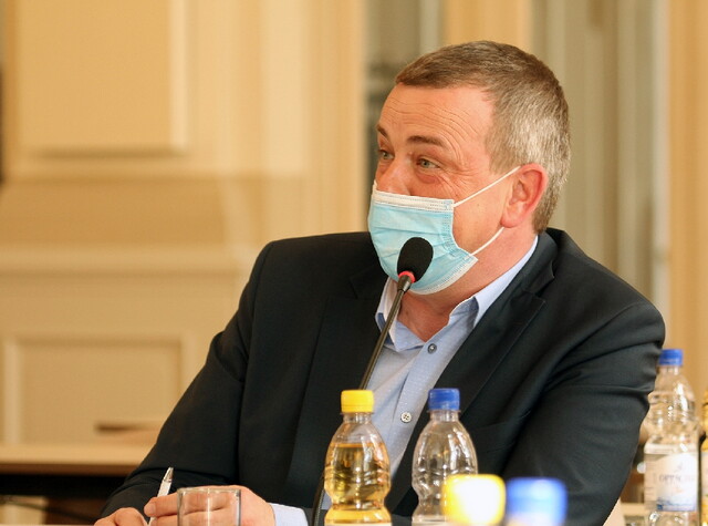 ein Mann sitzt an einem Tisch mit Mikrofon