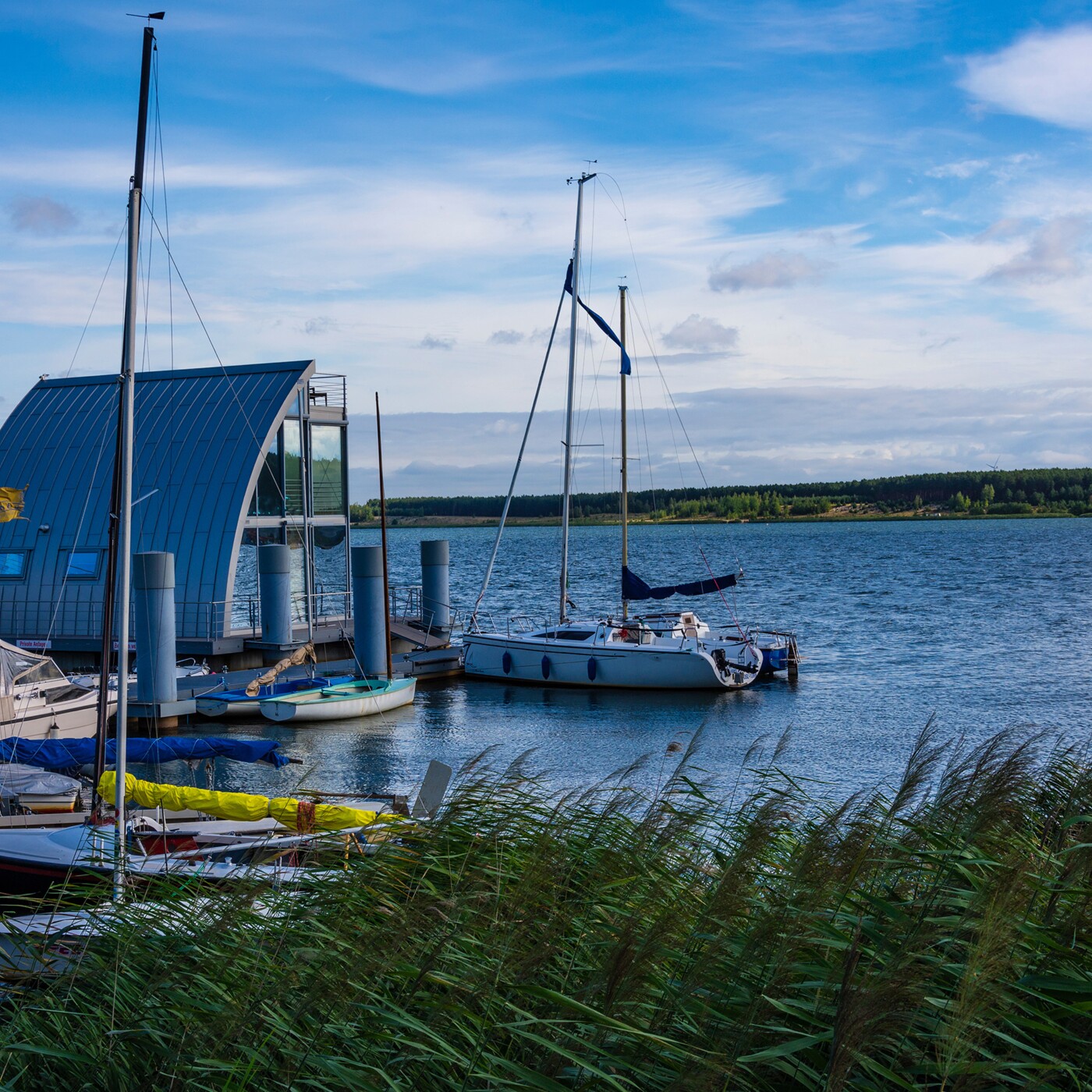 Ein See mit mehreren Booten und einem Hausboot.