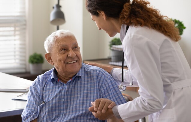 Eine Ärztin spricht mit einem freundlichen älteren Mann.