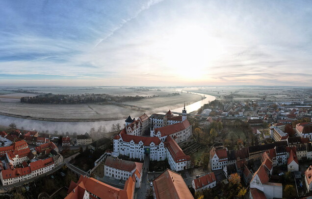 Eine Luftaufnahme der Stadt Torgau. Zu sehen sind das Schloss Hartenfels und die Elbe.