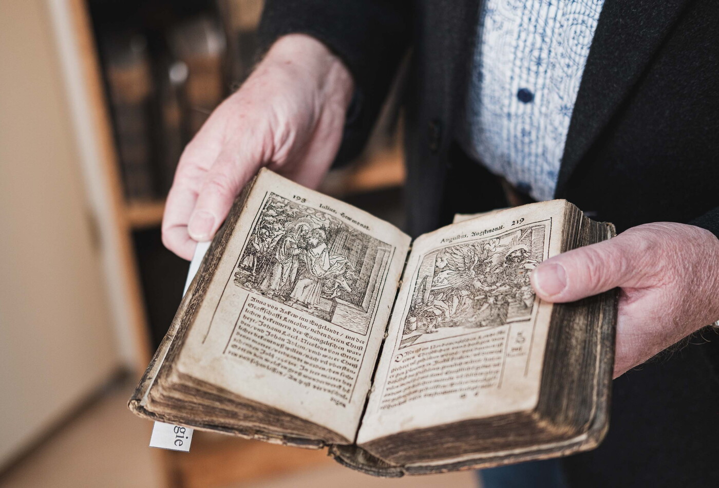 Eine Nahaufnahme von einem alten Buch, welches aufgeschlagen ist.