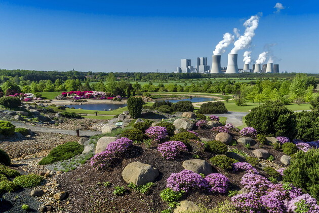 Im Vordergrund ist die Natur zusehen und im Hintergrund die Industrie