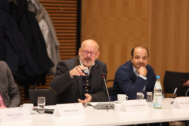 Zwei Männer bei einer Konferenz.