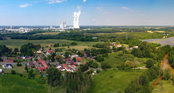 Im Vordergrund ist die Natur und im Hintergrund ist die Industrie abgebildet