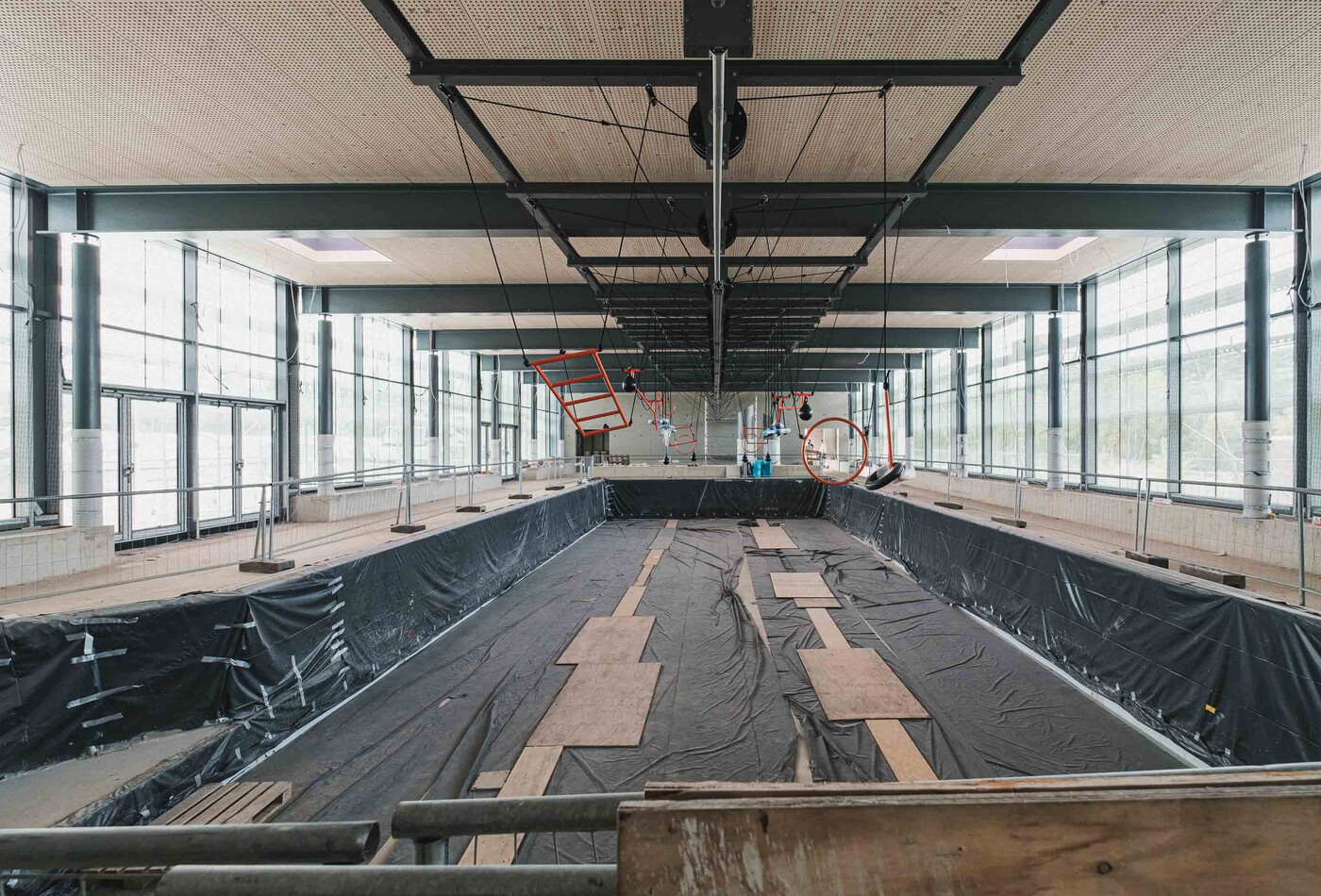 Das leere Schwimmbecken von Hoyerswerda, welches mit schwarzen Folien ausgelegt ist.