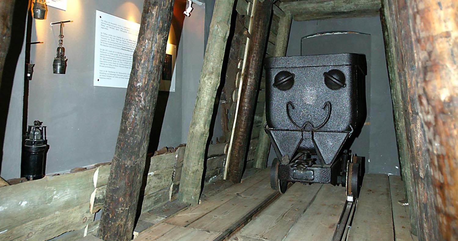Es ist das Borna Musem zusehen in der ein alter Transportwaggon auf Schienen zusehen.